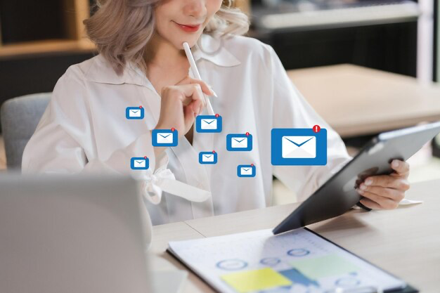 The girl is holding a tablet in her hands, email icons are in the foreground